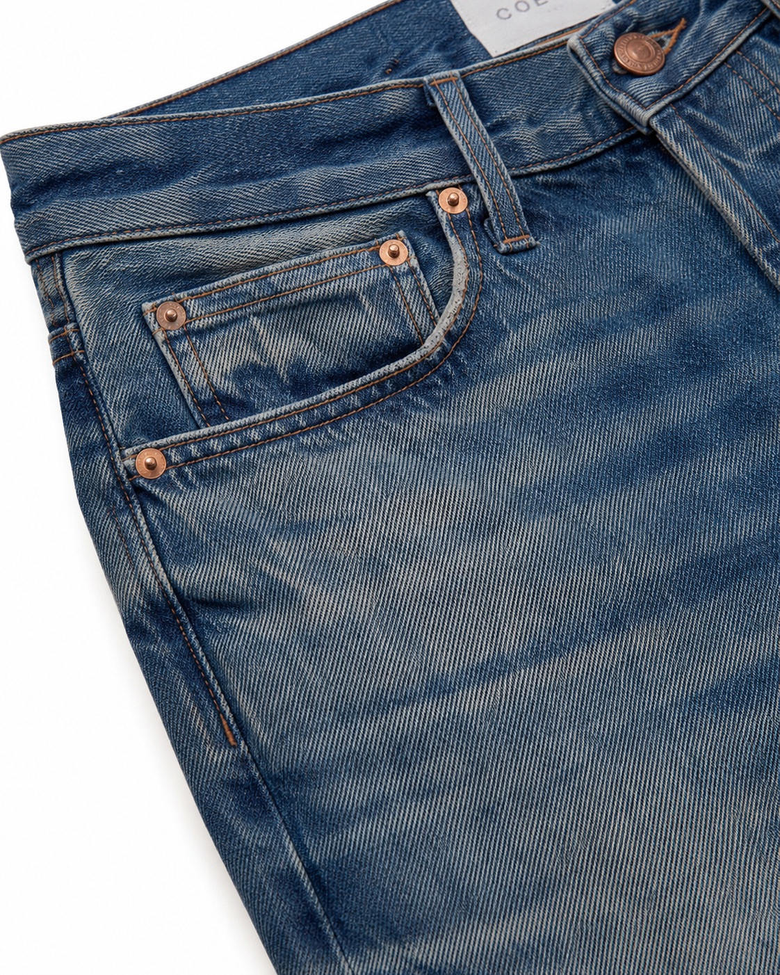 Jeans fabric and denim wash close-up showing texture, fade and stitching.